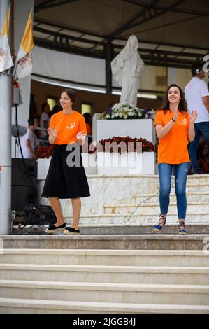 Freiwillige zeigen Hand- und Körperbewegungen für christliche Lieder beim Mladifest 2021, dem Jugendfestival in Medjugorje. Stockfoto