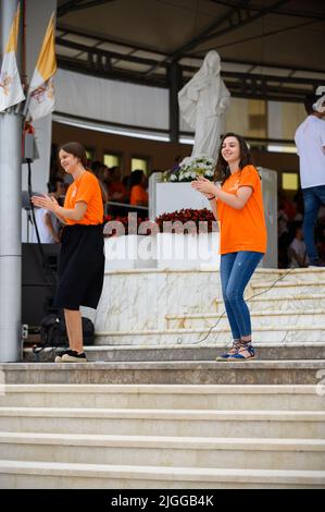 Freiwillige zeigen Hand- und Körperbewegungen für christliche Lieder beim Mladifest 2021, dem Jugendfestival in Medjugorje. Stockfoto