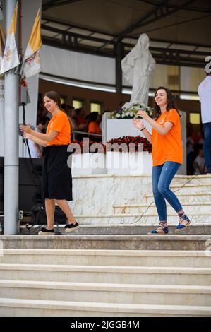 Freiwillige zeigen Hand- und Körperbewegungen für christliche Lieder beim Mladifest 2021, dem Jugendfestival in Medjugorje. Stockfoto