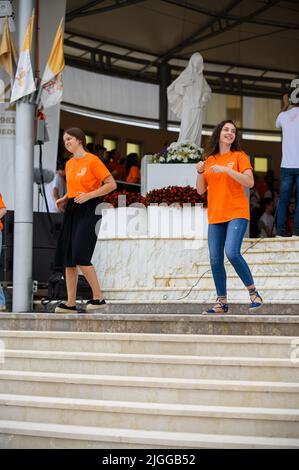 Freiwillige zeigen Hand- und Körperbewegungen für christliche Lieder beim Mladifest 2021, dem Jugendfestival in Medjugorje. Stockfoto