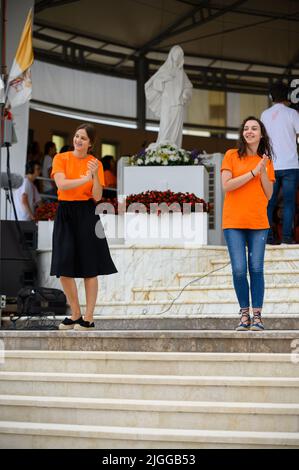 Freiwillige zeigen Hand- und Körperbewegungen für christliche Lieder beim Mladifest 2021, dem Jugendfestival in Medjugorje. Stockfoto