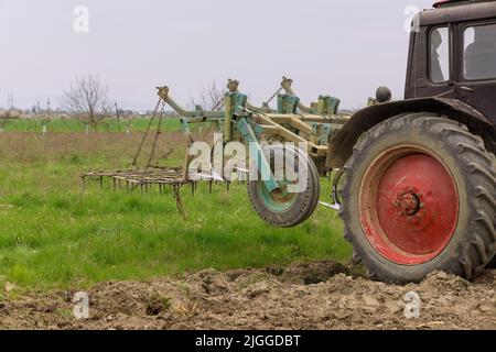 Traktor kultiviert und fräst Erde auf dem Feld. Stockfoto