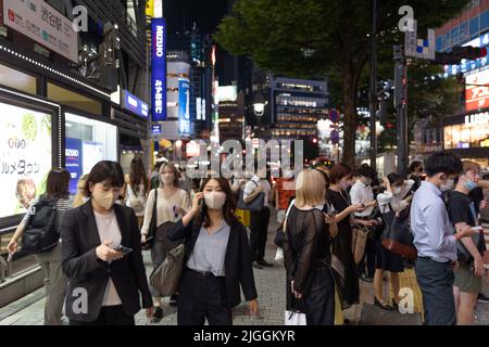 Fußgänger mit Gesichtsmasken warten an einer Ampel in der Nähe des Bahnhofs Shibuya im Zentrum von Tokio. Am 30. Juni 2022 kündigte der japanische Gesundheits-, Arbeits- und Sozialminister Shigeyuki Goto die überarbeitete Position der Regierung zum Maskentragen an: „Selbst wenn Sie draußen an anderen Menschen vorbeikommen, wie zum Beispiel beim Gehen zur Arbeit, ist es nicht notwendig, eine Gesichtsmaske zu tragen, solange wenig oder gar keine Gespräche geführt werden.“ Grundsätzlich gesagt, dass das Tragen einer Gesichtsmaske draußen nicht mehr empfohlen wird. Stockfoto