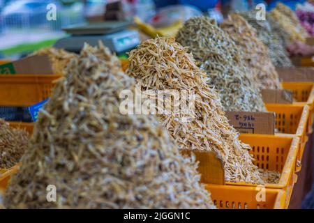 Ein großer Haufen getrockneter Fische auf einem Marktstand auf dem Frischmarkt von Kuala Lumpur. Trockener, knuspriger, kleiner Fisch, der in der Regel Bestandteil der malaysischen Famo ist Stockfoto