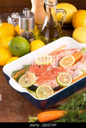 Steak mit rotem Fisch und geschnittenen Zitronen auf Weiß. Stockfoto