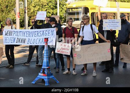 Dresden, Deutschland. 11.. Juli 2022. Klimaaktivisten der Gruppe 'Extinction Rebellion' blockieren eine Straße am Albertplatz. Die Klimaaktivisten fordern von der Bundesregierung einen sozial verträglichen Ausstieg aus fossilen Brennstoffen. Sie kritisieren insbesondere die Pläne für neue Ölbohrungen in der Nordsee und den Bau neuer LNG-Terminals für Erdgas. Kredit: Robert Michael/dpa/Alamy Live Nachrichten Stockfoto