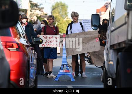 Dresden, Deutschland. 11.. Juli 2022. Klimaaktivisten der Gruppe 'Extinction Rebellion' blockieren eine Straße am Albertplatz. Die Klimaaktivisten fordern von der Bundesregierung einen sozial verträglichen Ausstieg aus fossilen Brennstoffen. Sie kritisieren insbesondere die Pläne für neue Ölbohrungen in der Nordsee und den Bau neuer LNG-Terminals für Erdgas. Kredit: Robert Michael/dpa/Alamy Live Nachrichten Stockfoto