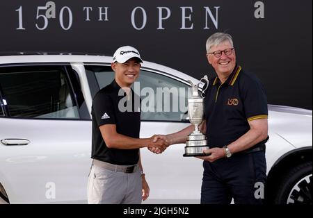 Collin Morikawa (links) aus den USA gibt den Claret Jug vor den Open Championships auf dem Old Course, St Andrews, an R&A-Chef Martin Slumbers zurück. Bilddatum: Montag, 11. Juli 2022. Stockfoto