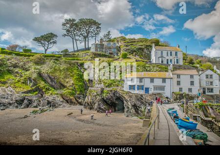 Eine Aufnahme von Häusern auf dem Hügel mit bewölktem Himmel in der Nähe von Polperro Strand Stockfoto