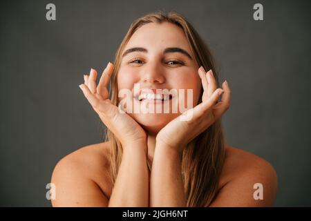 Close up fabulous Caucasian female framing her face with her hands Stockfoto