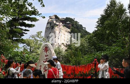 (220711) -- XI'AN, 11. Juli 2022 (Xinhua) -- Menschen besuchen den malerischen Ort des Berges Huashan in der nordwestlichen chinesischen Provinz Shaanxi, 10. Juli 2022. Der Berg Huashan ist einer der fünf berühmtesten malerischen Berge Chinas und bekannt für seine steilen und gefährlichen Gipfel. Die Management-Verwaltung des malerischen Gebietes Mount Huashan wird ihre Politik des freien Eintritts in diesem Monat fortsetzen, um mehr Besucher anzuziehen. (Xinhua/Tao Ming) Stockfoto