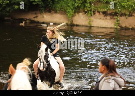 Eine junge Frau auf ihrem Pferd im Fluss Eden, Appleby Horse Fair, Appleby in Westmorland, Cumbria Stockfoto