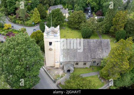 Eine Vogelperspektive auf die St. Oswald's Church, Grasmere, umgeben von grünen Bäumen in England Stockfoto
