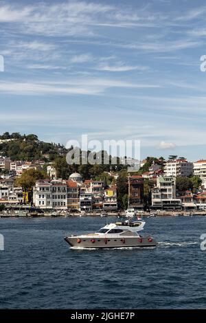 Blick auf eine Yacht, die am Bosporus durch das Viertel Arnavutkoy auf der europäischen Seite Istanbuls vorbeifährt. Es ist ein sonniger Sommertag. Wunderschöne Reiseszene. Stockfoto