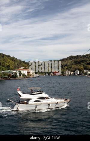 Blick auf die Yacht, die am Bosporus durch das Kanlica-Viertel auf der asiatischen Seite Istanbuls vorbeifährt. Es ist ein sonniger Sommertag. Wunderschöne Reiseszene. Stockfoto