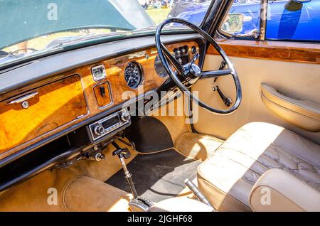 Der Innenraum einer A 1970 Austin Princess 1300 Vanden Plas mit Lenkrad und Nussbaum-Armaturenbrett auf der Motorshow in Reading, Großbritannien Stockfoto