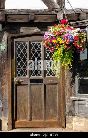 Ein hängender Korb und eine alte Eingangstür in den alten Straßen der Stadt York an einem Sommertag Stockfoto