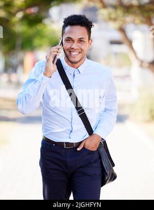 E-Mails erhalten Reaktionen. Telefonate beginnen Gespräche. Ein junger Geschäftsmann benutzt sein Telefon draußen in der Stadt. Stockfoto