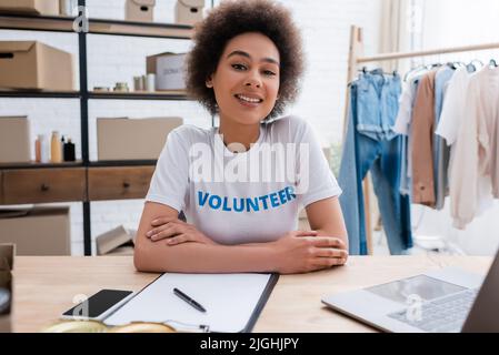 Happy african american Volunteer sitzt am Arbeitsplatz im Charity Center Stockfoto