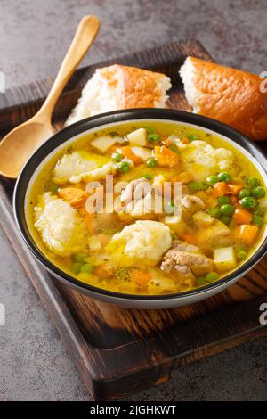 Eingemachtes Hühnersuppe mit Weizengratknödeln in einer Schüssel auf dem Tisch. Vertikal Stockfoto