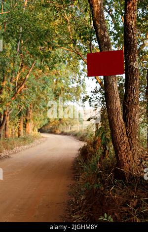 Am Baum wurde tagsüber im Freien ein leeres rotes Schild vernagt Stockfoto