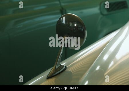 Seitenspiegel in der Nähe des Fahrzeugs. Heller, glänzender Seitenspiegel eines klassischen Retro-Autos. Stockfoto