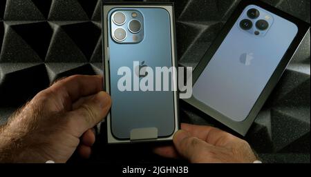 Paris, Frankreich - 28. Sep 2021: POV männliche Hand hält Unboxing neuen neuesten Apple Computers Handy Smartphone-Technologie Hintergrund Stockfoto