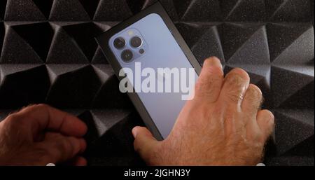 Paris, Frankreich - 28. Sep 2021: POV männliche Hand aus dem Karton entpackt neuen neuesten Apple Computers Handy Smartphone-Technologie Hintergrund Stockfoto