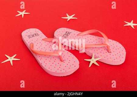 Strandzubehör. Flip Flops und Seesterne auf farbigem Hintergrund. Draufsicht Mock up mit Kopierbereich. Stockfoto