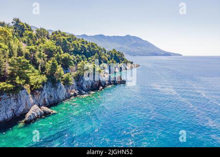 Malerisches Meer Adriaküste von Montenegro. Türkisfarbenes Mittelmeer und felsige Küste mit immergrünen Nadelbäumen. Wunderschöne Sommerlandschaft Stockfoto