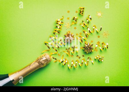 Kreative, flache Lay-Komposition mit einer Flasche Champagner und Platz für Text auf farbigem Hintergrund. Champagner-Flasche mit bunten Party-Streamer. Urlaub Stockfoto