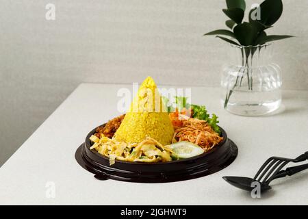 Kleiner Kegelförmiger Gelber Reis Oder Tumpeng Mini Nasi Kuning. Indonesisches Festessen für Indoneia Unabhängigkeitstag 17 Agustus Stockfoto