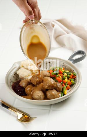 Köstliche hausgemachte schwedische Fleischbällchen Kottbullar mit Pilzcreme-Sauce, gekochtem Gemüse und Lingonberry-Marmelade, Pilzsauce Stockfoto