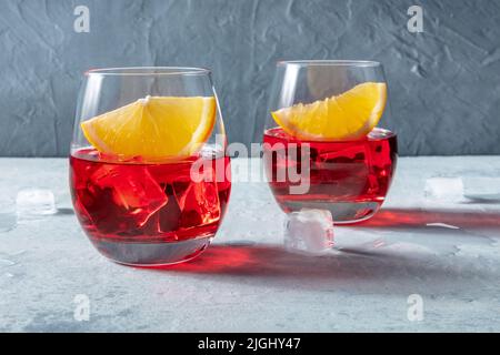 Campari-Aperitif mit frischen Orangenscheiben auf Schiefergrund. Sommercocktail mit Eis, einem klassischen alkoholischen Getränk Stockfoto