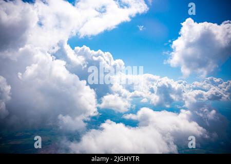 Luftaufnahme Szene der ländlichen Ort, die unter weißen flauschigen Wolken und blauen hellen Himmel Hintergrund versteckt. Stockfoto