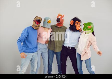 Lustige verschiedene Menschen in Tiermasken umarmen Stockfoto