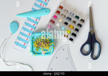 Nähen von Gegenständen und Nähwerkzeugen. Schneiderschere, Maßband, Garnspulen, Stifte Stockfoto