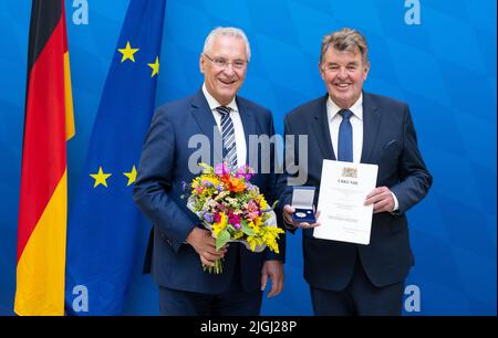 11. Juli 2022, Bayern, MŸnchen: Der bayerische Innenminister Joachim Herrmann (l, CSU) verleiht der Bayerischen Staatsmedaille "Stern der Sicherheit" den ehemaligen Landesvorsitzenden der Bayerischen Polizeigewerkschaft Harald Schneider. Mit der Bayerischen Staatsmedaille "Stern der Sicherheit" würdigt der Bayerische Innenminister seit 2013 herausragende Verdienste um die innere Sicherheit. Foto: Sven Hoppe/dpa Stockfoto