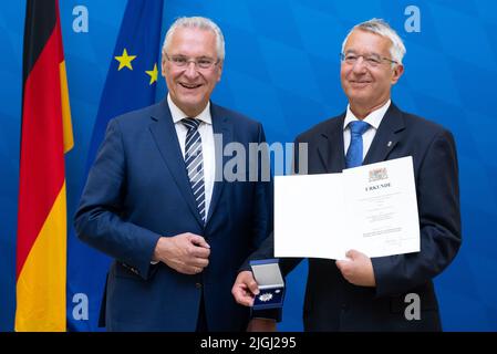 11. Juli 2022, Bayern, MŸnchen: Joachim Herrmann (l, CSU), Bayerischer Innenminister, verleiht der Bayerischen Staatsmedaille "Stern der Sicherheit" Wilhelm Schmidbauer, ehemaliger Polizeichef der Bayerischen Polizei. Mit der Bayerischen Staatsmedaille "Stern der Sicherheit" würdigt der Bayerische Innenminister seit 2013 herausragende Verdienste um die innere Sicherheit. Foto: Sven Hoppe/dpa Stockfoto