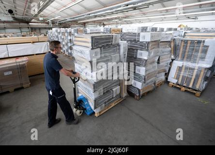 Ludwigsburg, Deutschland. 11.. Juli 2022. Ein Mitarbeiter der Feuerwehr schiebt eine Palette mit Notfallbetten in ein Lager für Notfälle des Bevölkerungsschutzes des Landkreises Ludwigsburg. Damit können im Falle eines Gasnotfalls mögliche Heizhallen ausgestattet werden. Quelle: Bernd Weißbrod/dpa/Alamy Live News Stockfoto