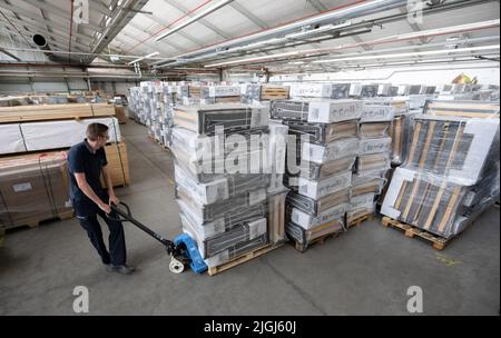 Ludwigsburg, Deutschland. 11.. Juli 2022. Ein Mitarbeiter der Feuerwehr schiebt eine Palette mit Notfallbetten in ein Lager für Notfälle des Bevölkerungsschutzes des Landkreises Ludwigsburg. Damit können im Falle eines Gasnotfalls mögliche Heizhallen ausgestattet werden. Quelle: Bernd Weißbrod/dpa/Alamy Live News Stockfoto