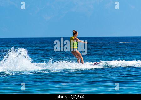 Frau genießt Wasserski am Koukounaries Strand auf der Insel Skiathos, Sporaden, Griechenland Stockfoto