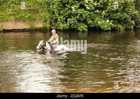 Ein Teenager, der auf seinem Pferd durch den Fluss Eden, Appleby Horse Fair und Appleby in Westmorland, Cumbria, reitet Stockfoto