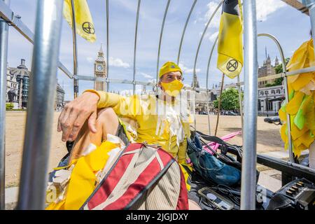 London, Großbritannien. 11.. Juli 2022. Die „Kanaren“ des Extinction Rebellion fordern einen Stopp aller neuen Kohleminen in Großbritannien, da sie am Rande eines sonnenversengten Parliament Square protestieren. Kredit: Guy Bell/Alamy Live Nachrichten Stockfoto