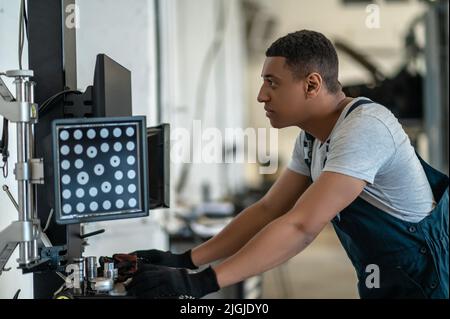 Automechaniker, der den Desktop-PC am Arbeitsplatz nutzt Stockfoto