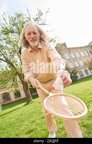 Positiv entzückter grauhaariger Mann, der die Kamera ansah Stockfoto