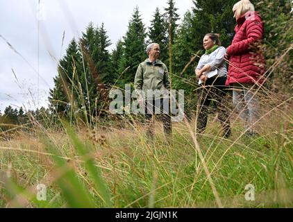 11. Juli 2022, Thüringen, Schmiedefeld am Rennsteig: Bettina Hoffmann (r-l), Parlamentarische Staatssekretärin des Bundesumweltministeriums, Britta Trostorff, Projektleiterin der Naturstiftung David, Und Olaf Bandt, Vorsitzender des Bundes für Umwelt und Naturschutz Deutschland, inspizieren beim offiziellen Start des groß angelegten Naturschutzprojekts "Bäche, Mauren und Bergwiesen im Thüringer Wald" eine Bergwiese. Das Bundesumweltministerium, das Thüringer Umweltministerium, der Bund und die Naturstiftung David starten das Projekt Stockfoto