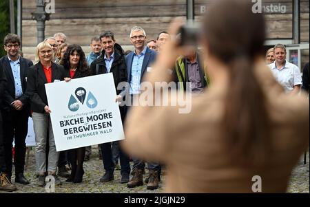 11. Juli 2022, Thüringen, Schmiedefeld am Rennsteig: Gäste der Veranstaltung und Projektteilnehmer stehen beim offiziellen Start des groß angelegten Naturschutzprojekts "Bäche, Mauren und Bergwiesen im Thüringer Wald" zu einem Gruppenfoto zusammen. Das Bundesumweltministerium, das Thüringer Umweltministerium, der Bund und die Naturstiftung David starten das Projekt. Durch menschliches Eingreifen können Ströme und Moor ihre ökologischen Funktionen nur eingeschränkt erfüllen. Mangelnde landwirtschaftliche Nutzung gefährdet die Zukunft wertvoller Bergwiesen. Stockfoto