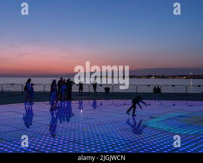 Besucher bei Nikola Basic's Sun Salutation Lighting Display, Istarska Obala Promenade, Zadar, Kroatien Stockfoto