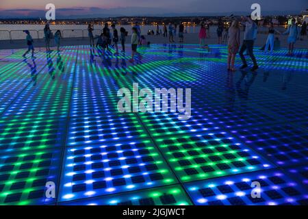 Besucher bei Nikola Basic's Sun Salutation Lighting Display, Istarska Obala Promenade, Zadar, Kroatien Stockfoto